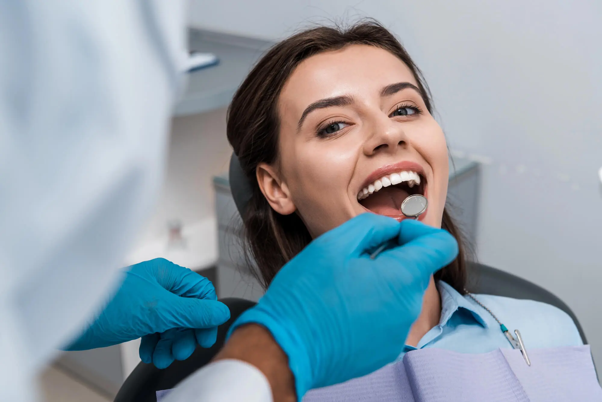 Smiling woman receiving dental exam Dentist in Goose Creek