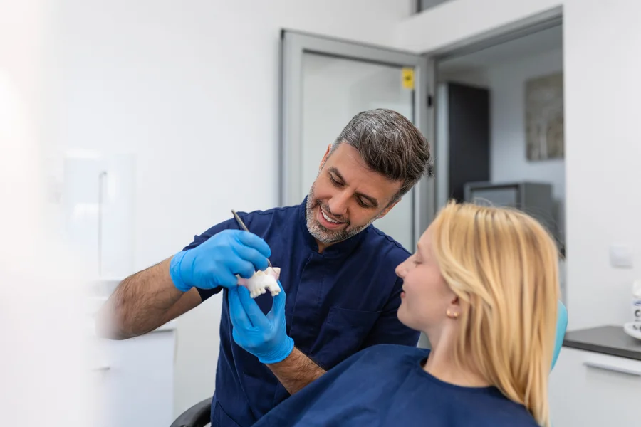 bridge-dental-charleston-sc-dentist-showing-a-patient-a-tooth-model-with-a-dental-tool